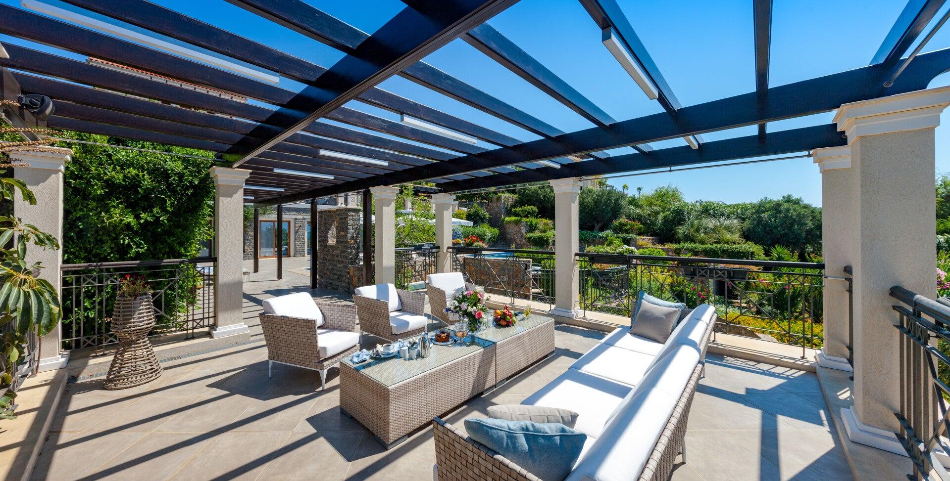 Overkapping met glazen dak boven een terras met loungeset